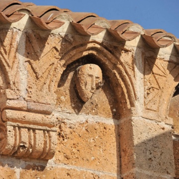 Monteleone Rocca Doria, chiesa parrocchiale di Santo Stefano. Figura umana collocata in una delle lunette degli archetti. (foto Ivo Piras)